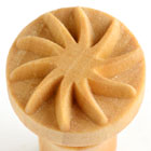 Close-up of a ceramic texture stamp with a starburst pattern, used for decorating clay and pottery surfaces.