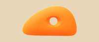 Flexible orange clay rib tool with a hole, used for shaping and smoothing pottery surfaces at Georgies Ceramic & Clay Company.