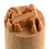 Close-up of a wooden clay stamp with a textured design, used for decorating pottery and ceramic projects.
