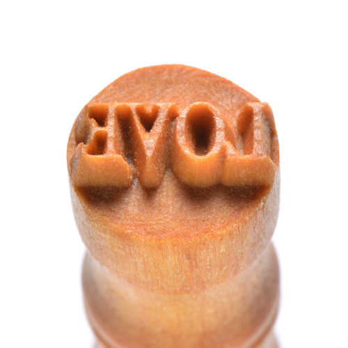 Wooden clay stamp tool featuring the word LOVE in reverse for creating impressions in ceramics or pottery.