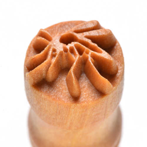Wooden pottery tool with a detailed leaf-patterned end, used for texture application in ceramics and clay decorating.
