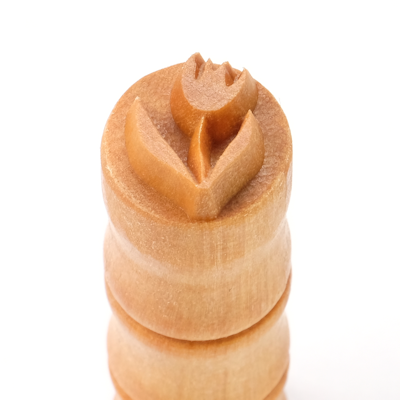 Wooden stamping tool with a tulip design, used for decorating ceramics and pottery at Georgies Ceramic & Clay Company.