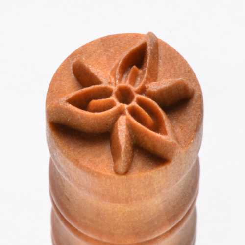 Carved ceramic stamp with a floral design, ideal for enhancing pottery and clay projects with textural details.