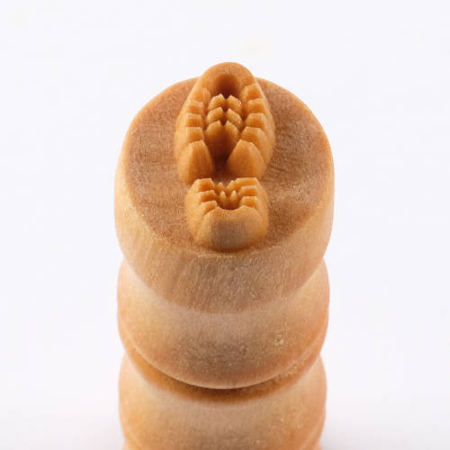 Carved ceramic texture tool with intricate patterns, designed for applying detailed designs on clay surfaces.
