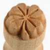 Detail of a wooden pottery stamp featuring a flower design, used for texturing clay in ceramics and pottery projects.