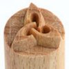Wooden carving tool with an intricate design on the tip, used for detailing ceramics or pottery textures.
