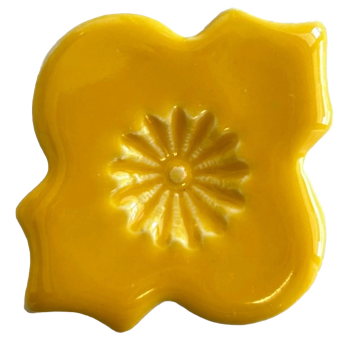 Bright yellow ceramic flower-shaped glaze sample with a floral design, ideal for decorative pottery and sculpture.