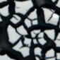 Close-up of a black crackle glaze on ceramics, revealing a network of fine lines against a smooth, glossy surface.