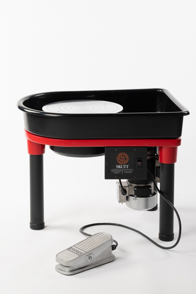 Skutt pottery wheel with red and black design, featuring a foot pedal and a circular throw area for clay shaping.