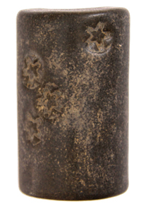 Ceramic black clay stamp with decorative star patterns, used for imprinting designs in pottery and sculpture.