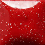 Detailed close-up of a glossy red ceramic glaze with white speckles, suitable for pottery and sculpture applications.