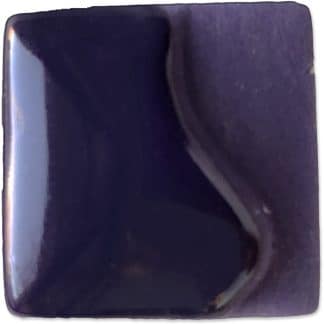 Deep indigo ceramic glaze sample showcasing a glossy finish and subtle wave design, perfect for decorative pottery.
