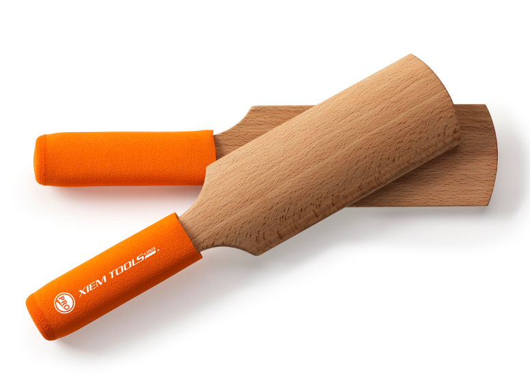 Two Xiem Tools wooden clay modeling tools with orange cushioned grips, designed for shaping and smoothing ceramics.
