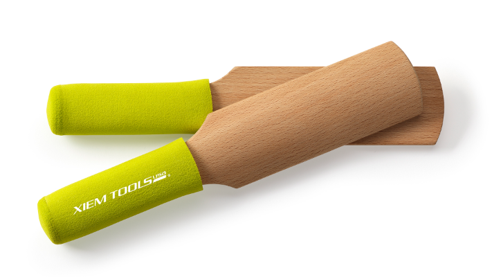 Two Xiem Tools wooden pottery tools with vibrant green rubber grips, designed for sculpting and shaping clay.