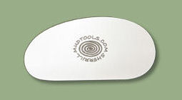 White ceramic rib tool on a green background, useful for shaping and smoothing clay in pottery and sculpting.