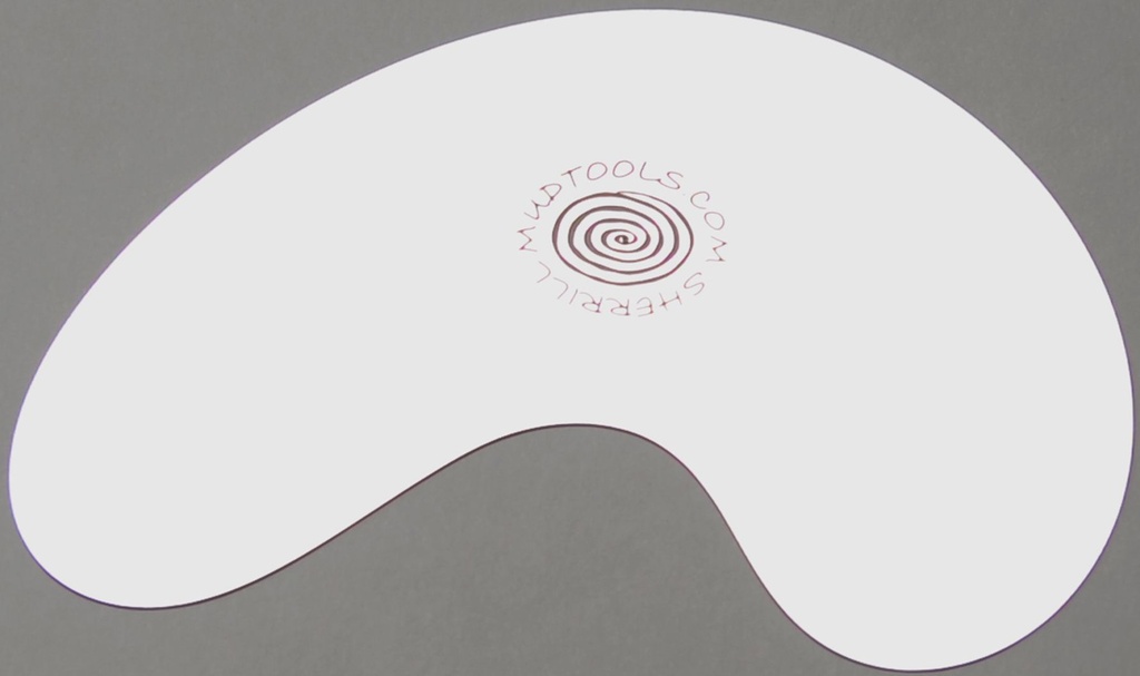 White ceramic shaping tool with a spiral logo, resting on a gray surface, used for manipulating clay in studio work.