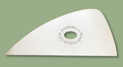 Sherrill ceramic trimming tool with a rounded edge and central hole, ideal for shaping and refining clay surfaces.