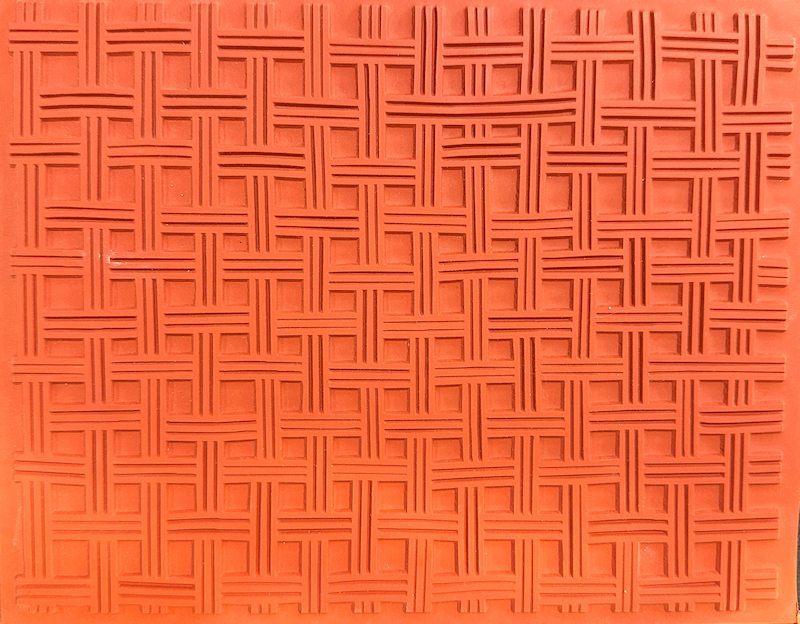 Textured red clay slab featuring a woven pattern, ideal for ceramic surface decoration or sculpture techniques.