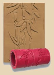 Red clay texture roller with bamboo design next to an impression of the design on a clay slab.