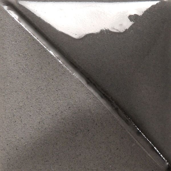 Close-up of a ceramic tile featuring a matte gray surface with a glossy white accent, showcasing glaze application techniques.