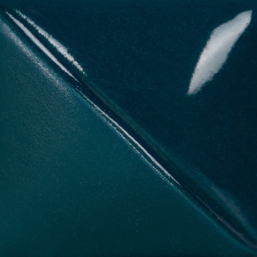 Teal ceramic glaze sample with a glossy finish, showcasing a smooth, gradient transition between deep blue and dark green hues.