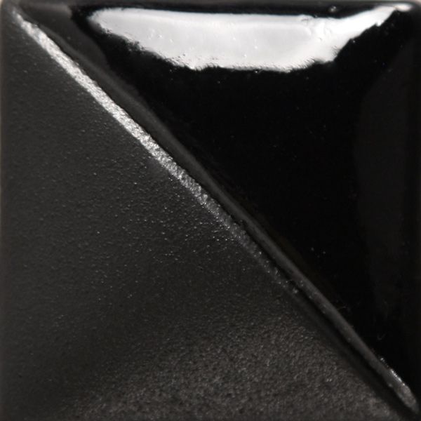 Black ceramic glaze sample with a glossy finish, showcasing a smooth texture and sharp diagonal contrast.