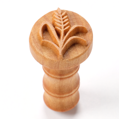 Wooden pottery stamp with a leaf design, used for decorating clay, ideal for creating textured surfaces on ceramics.