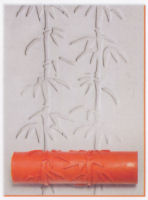 Textured clay surface featuring bamboo imprints from a ceramic roller, with an orange tool prominently displayed.