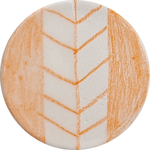 Round ceramic tile featuring an orange chevron design, showcasing underglaze work before firing.