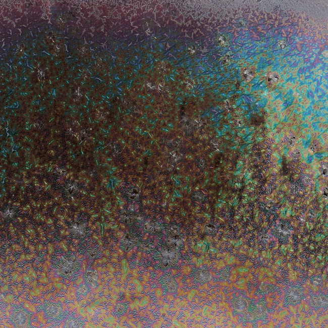 Colorful, iridescent glaze texture resembling decorative pottery finishes, showcasing subtle variations and patterns.