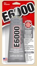 E6000 industrial adhesive tube, ideal for ceramic projects, bonding clay, and pottery repairs in a studio setting.