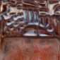Textured ceramic glaze with rich brown hues and subtle blue accents, ideal for pottery decoration and glazing techniques.