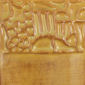 Embossed ceramic texture showcasing intricate carved details resembling a bridge and rocks on a clay surface.