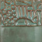 Textured ceramic surface with a teal glaze and copper detailing, showcasing intricate design for pottery and sculpture.