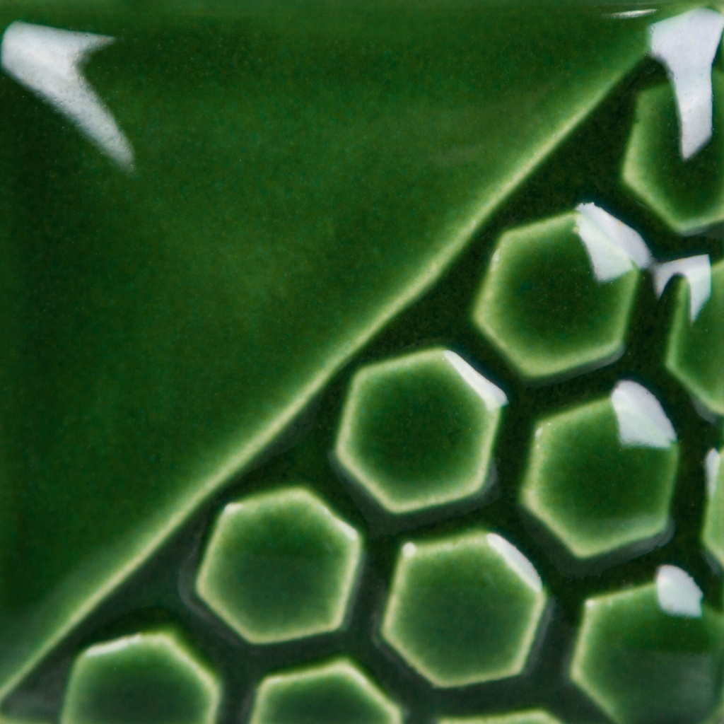 Green glazed ceramic tile featuring a hexagonal pattern, showcasing texture and depth ideal for pottery and decorating.