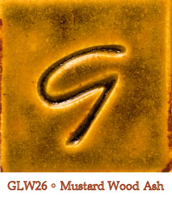 Square tile featuring a rich mustard wood ash glaze (GLW26) with a textured letter 'G' imprint, displaying warm yellow-orange tones.