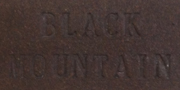 Close-up of a clay surface with BLACK MOUNTAIN embossed, showcasing texture suitable for glazing and pottery work.