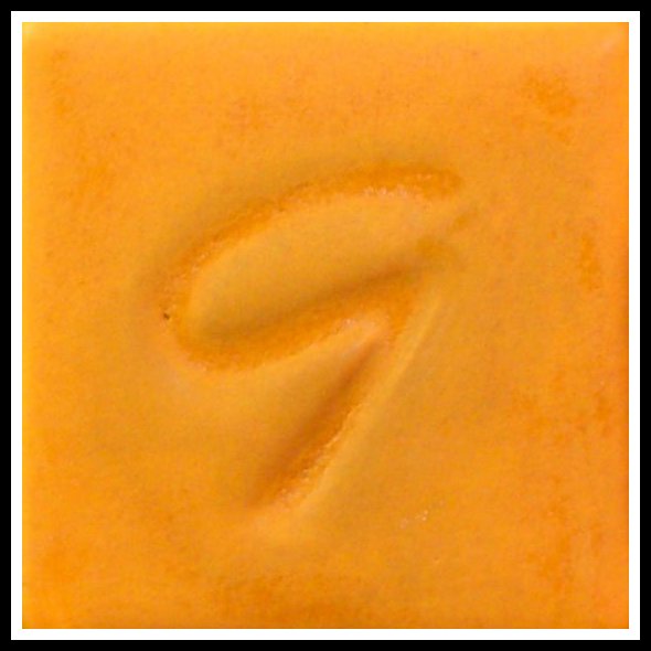 Orange ceramic glaze sample with an embossed letter G, showcasing texture for pottery decoration.