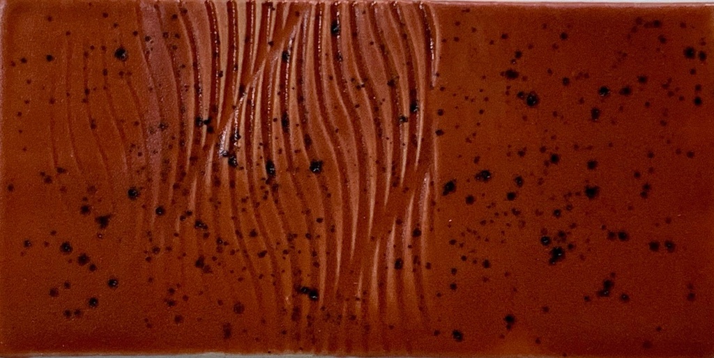 Textured ceramic tile with reddish-brown glaze, featuring subtle lines and dark speckles for decorative use in pottery.