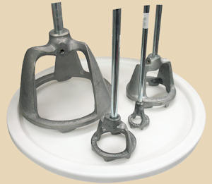 Metal pottery tools including pottery bats and support rods on a white platter, used for shaping and forming clay.