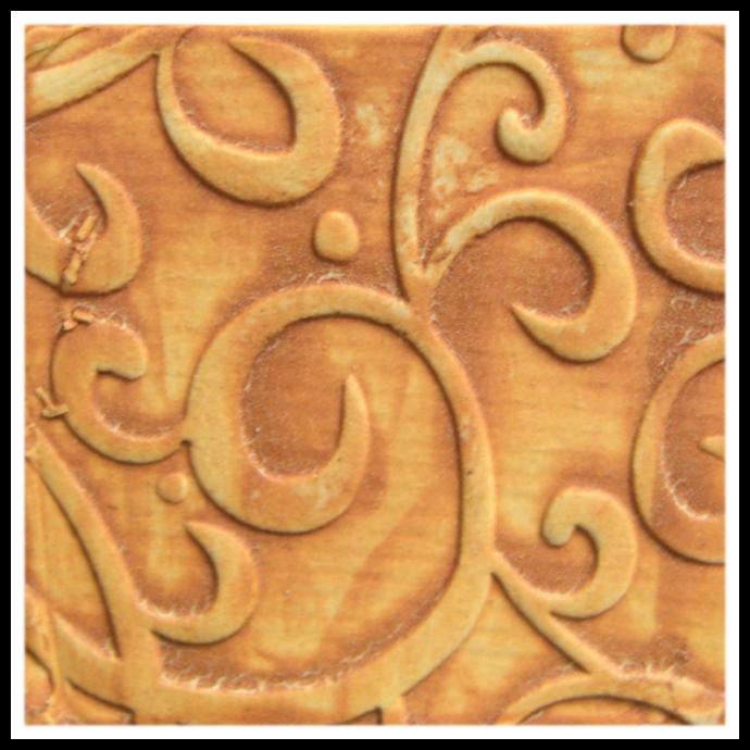 Close-up of a ceramic texture with embossed swirling designs, featuring warm orange and brown tones, suitable for pottery decoration.