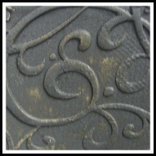 Black textured clay surface featuring intricate scroll designs, ideal for pottery decoration and sculptural techniques.