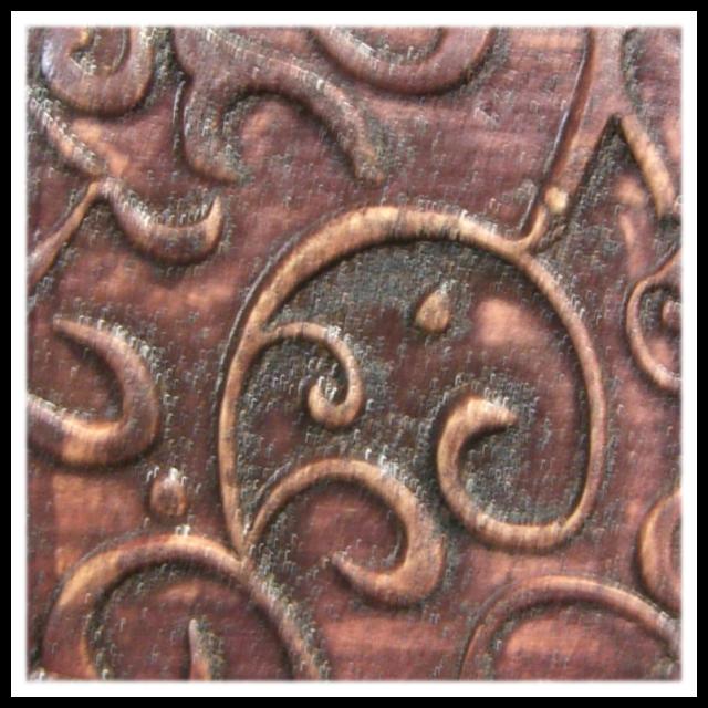 Close-up of an embossed clay texture featuring swirling designs, ideal for pottery decoration or ceramic sculpting.