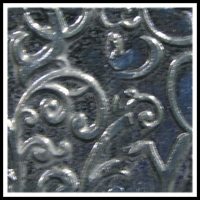 Close-up of a textured ceramic surface featuring intricate swirls and patterns, ideal for clay decoration techniques.