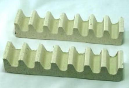 Two ceramic kiln furniture supports, featuring a wavy design for optimal ventilation during firing.