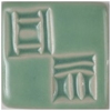 Ceramic tile sample featuring a glossy green glaze with textured patterns, suitable for pottery decoration or sculpture.