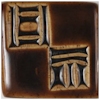 Dark brown ceramic plate with carved geometric designs, showcasing texture and potential glaze effects for pottery.