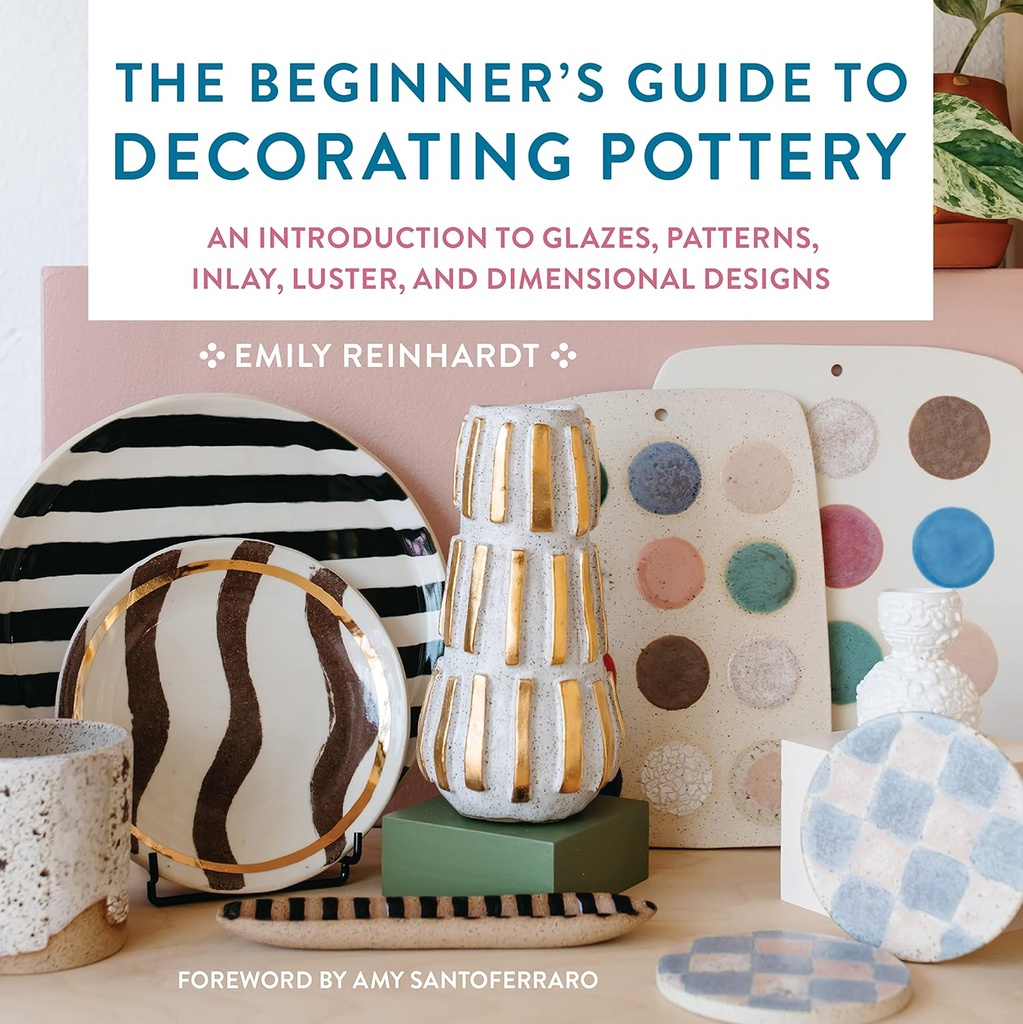 Decorative pottery pieces, including glazed plates and textured vases, displayed alongside a book on ceramic decoration techniques.