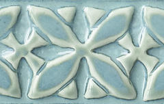 Ceramic tile featuring an intricate floral design, glazed in soft blue and cream colors, ideal for decorative applications.