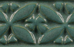 Teal ceramic tile featuring leaf and floral relief design, showcasing a glossy glaze finish ideal for decorative pottery.